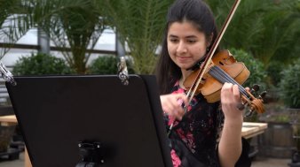 Ein junges Mädchen spielt Geige. 