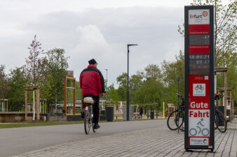 ein Radfahrer auf einem Radwege, daneben eine Informationssäule mit digitaler Anzeige