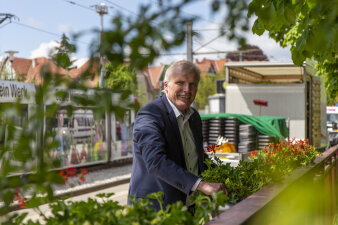 der Erfurter Oberbürgermeister hängt einen Blumenkasten an einem Geländer auf