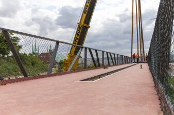 Blick auf ein Stahlsegment einer Brücke, das noch am Kran hängt