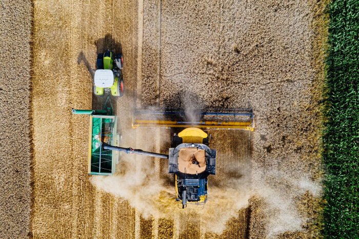 Luftaufnahme eines Mähdreschers und Traktors bei der Ernte