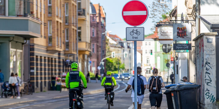 Eine Straße, die mit einem Einbahnstraßenschild versehen ist und dem Zusatzzeichen "für Radfahrer frei"