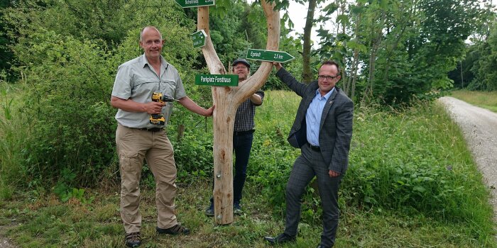 Foto: Beschilderung Wanderweg Egstedt © ThüringenForst drei Männer stehen an einem Wegweiser, der verschiedene Wanderwege ausschildet