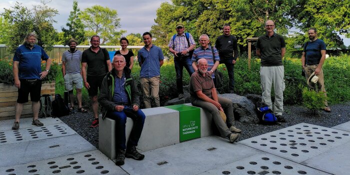 Foto: Der Naturschutzbeirat auf Sommerexkursion © Stadtverwaltung Erfurt Mehrere Personen stehen und sitzen nebeneinander, im Hintergrund sind Wiese und Bäume zu sehen.