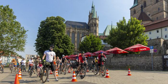 mehrere Radfahrende stehen in Reihen auf dem Erfurter Domplatz und warten auf den Start einer Radtour