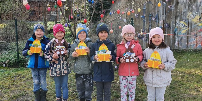 Foto: Ostergrüße aus dem Kindergarten Bussibär © Bärbel Weber Fünf Kinder stehen nebeneinander und halten Osterkörbchen in ihren Händen.