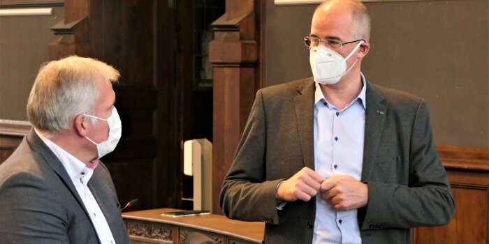 Foto: Pressegespräch zum Pandemiestab © Stadtverwaltung Erfurt Zwei Männer mit Gesichtsmaske stehen nebeneinander in einem historischen Saal und schauen sich.
