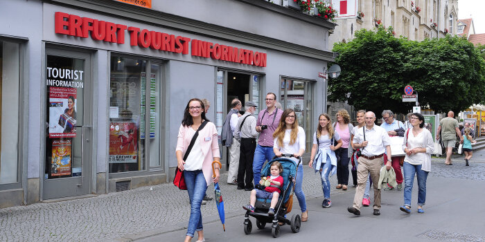 eine Gruppe von Menschen läuft vor der Erfurt Tourist Information