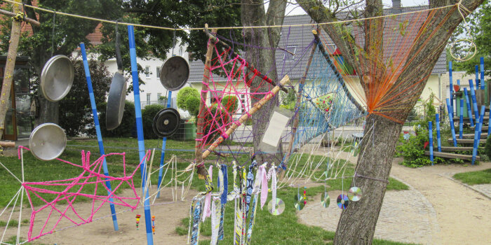 Foto: Kita "Dittelstedter Knirpse" © Stadtverwaltung Erfurt Die Freifläche einer Kita mit Basteleien an einem Baum