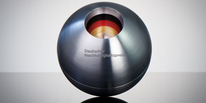 ein Preis in runder metallischer Form mit dem Aufdruck "Deutscher Nachhaltigkeitspreis"