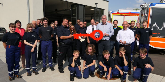 Foto: Schlüsselübergabe für Feuerwehrgerätehaus in Erfurt-Hochheim © Stadtverwaltung Erfurt Der Oberbürgermeister übergibt einen symbolischen Schlüssel an viele Feuerwehrleute