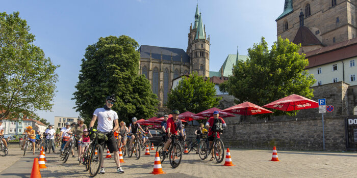 mehrere Radfahrende stehen in Reihen auf dem Erfurter Domplatz und warten auf den Start einer Radtour