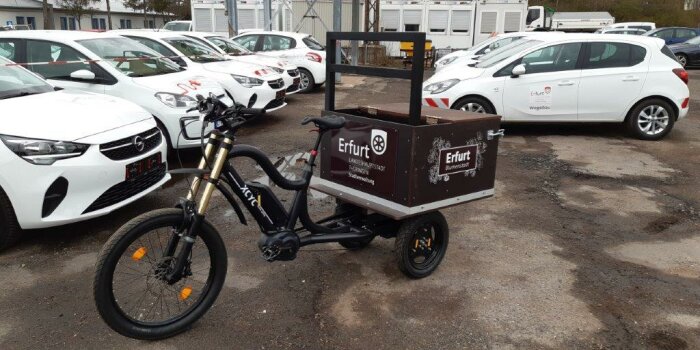 Vor dem Fuhrpark der Stadtverwaltung Erfurt steht ein Lastenrad mit einer großen braunen Ladefläche.