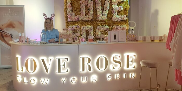 Foto: Pop-up-Store F11 - Love Rose 2021 © Love Rose Cosmetics GmbH & Co. KG Eine Frau steht an einer Ladentheke.