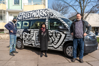 Erfurter Graffitikünstler Dr. Hot verwandelt neuen Streetworker-Bus in Superheldenmobil Drei Personen stehen vor dem bemalten Fahrzeug