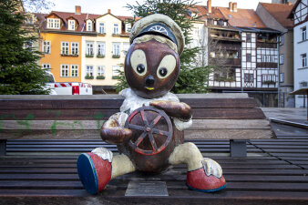 eine Pittiplatsch-Figur sitzt auf einer Bank