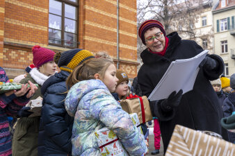 Eine Frau zeigt mehreren Kindern einen Kalender.