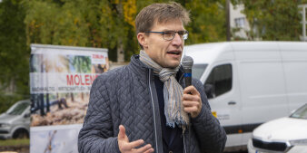 Ein Mann hält eine Ansprache auf einer Baustelle.