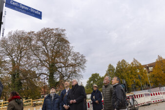 eine Gruppe von Menschen steht unter einem Straßenschild