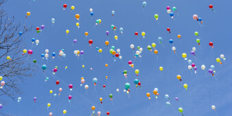 Bunte Luftballons steigen in den Himmel auf. 