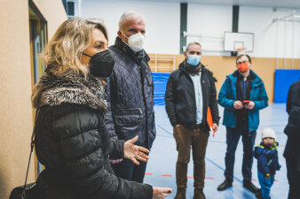 Mehrere Menschen stehen in einer Turnhalle