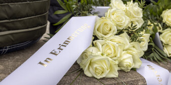 Blumen mit Trauerband liegen an der Schule.