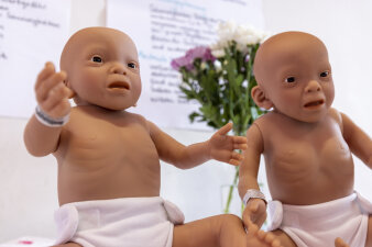 Zwei Puppen veranschaulichen ein Krankheitsbild.