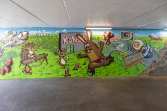 ein Graffiti an einer Wand zeigt verschiedene Tiere wie Hase, Igel und Schnecke