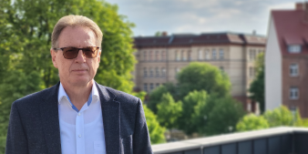 Ein Mann mit Jacket und getönter Brille. 