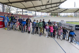 Gruppenfoto von Schulkindern auf einer Radrennbahn