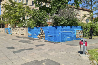 eine mit Graffiti in den Farben Blau und Beige gestaltete Mauer