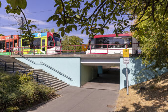 eine Fußgängerunterführung, darüber fahren zwei Straßenbahnen