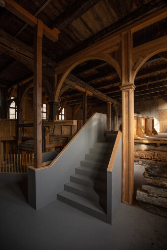 Treppen, Pfeiler und Holzbalken im Inneren eines alten Hauses