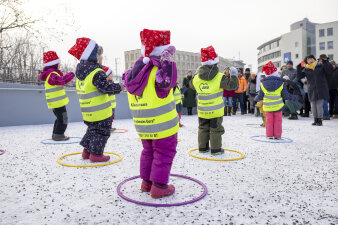 Kinder tanzen auf einer verschneiten Brücke.