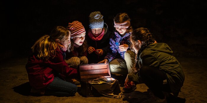 Foto: Neues Ferienangebot auf dem Petersberg: Suche nach Dagoberts Schatz © Erfurter Tourist und Marketing Kinder hocken im Kreis und betrachten einen Gegenstand