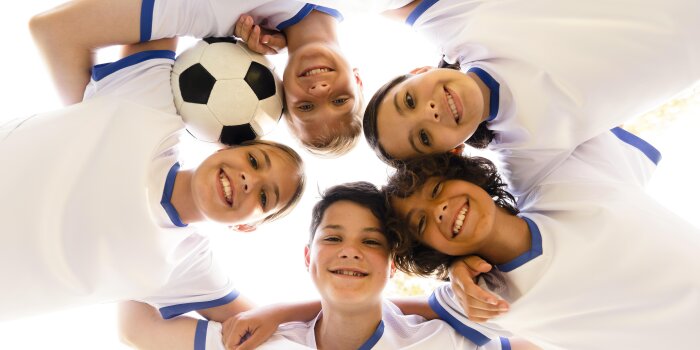 Kinder in Sportkleidung mit einem Ball