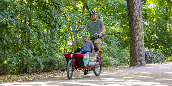 ein Mann und ein Junge auf einem Lastenrad