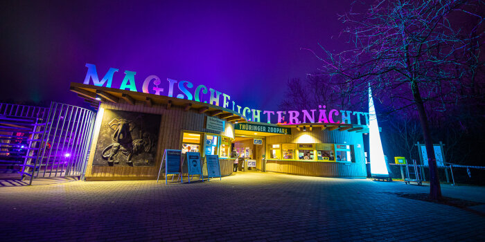 Über dem Eingang zu einem Zoopark ist ein Schriftzug angebracht. Dieser leuchtet im Dunkeln.