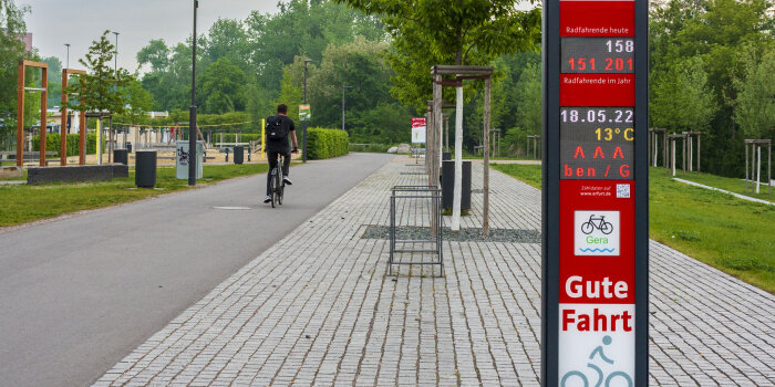 eine digitale Stele mit verschiedenen Anzeigen an einem Radweg
