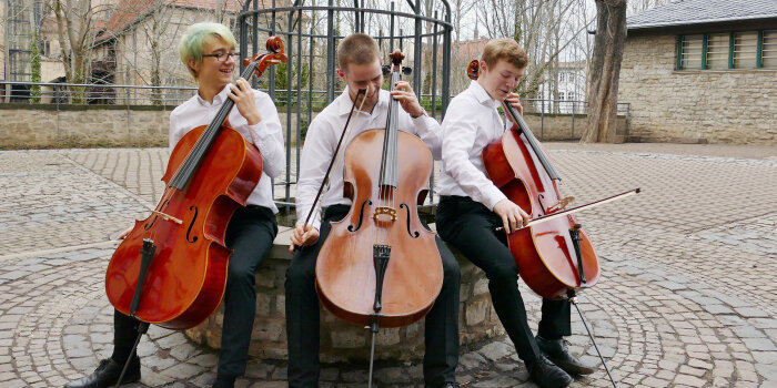 drei junge Menschen mit Cello