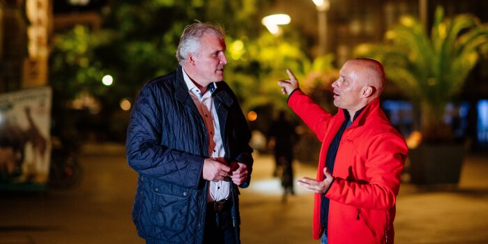 Zwei Männer diskutieren miteinander in der Öffentlichkeit.