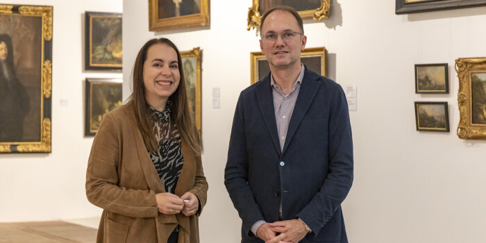 eine Frau und ein Mann stehen in einer Gemäldegalerie