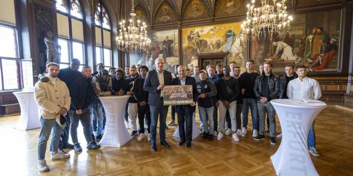 Foto: Empfang des FC Rot-Weiß Erfurt © Stadtverwaltung Erfurt Viele Männer stehen nebeneinander in einem historischen Saal.
