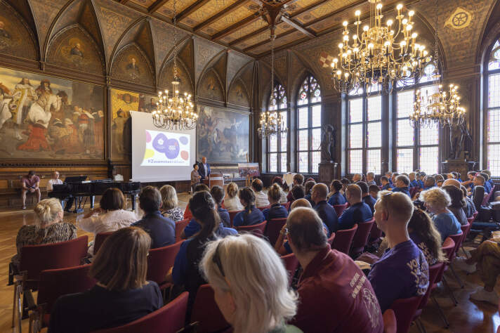 Blick in einen Festsaal, voll mit Menschen.