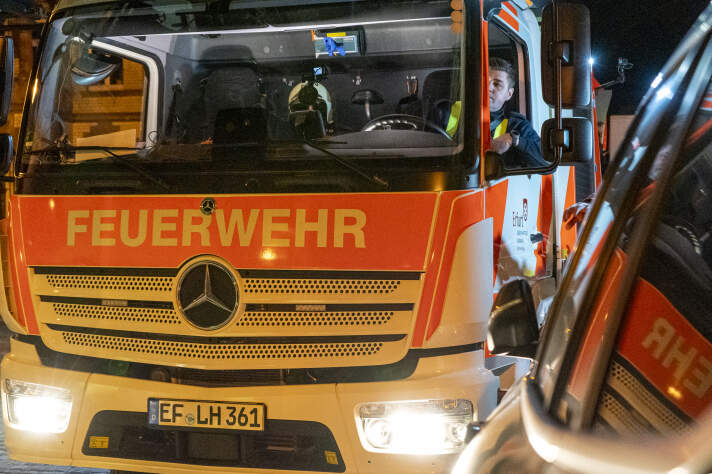 Ein Feuerwehrmann sitzt in der Fahrerkabine eines Drehleiterfahrzeuges.