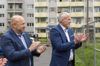 Zwei Männer in Anzügen applaudieren.