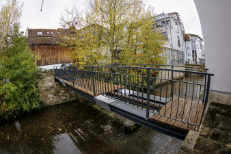 eine frisch sanierte Brücke mit Metallgeländer 