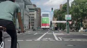 Foto: Ride-Verkehrsbeschleunigung durch Information und Digitalisierung © GEVAS Software GmbH Ein Fahrradfahrer fährt auf einen Schutzstreifen auf eine grüne Ampel zu. Ein Handy zeigt ihm die "grüne Welle" an.