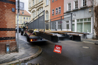 ein Traktor manöviert eine Brücke auf einem Anhänger um eine Straßenecke