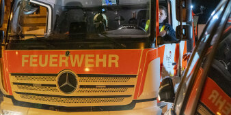 Ein Feuerwehrmann sitzt in der Fahrerkabine eines Drehleiterfahrzeuges.